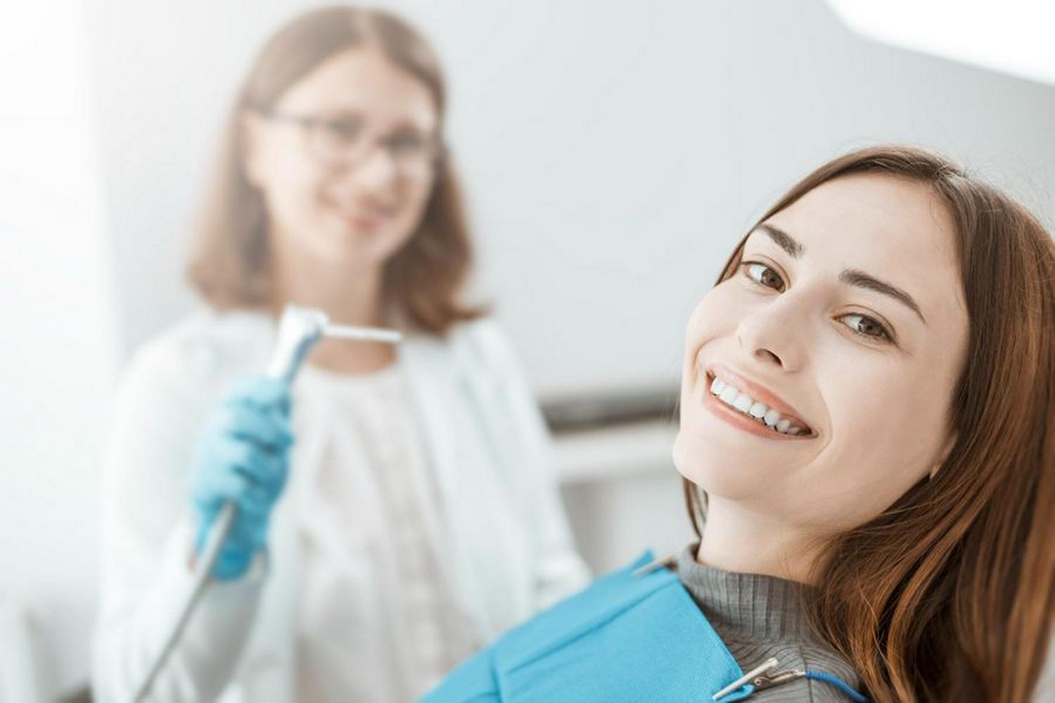 Uśmiechnięta kobieta na fotelu dentystycznym