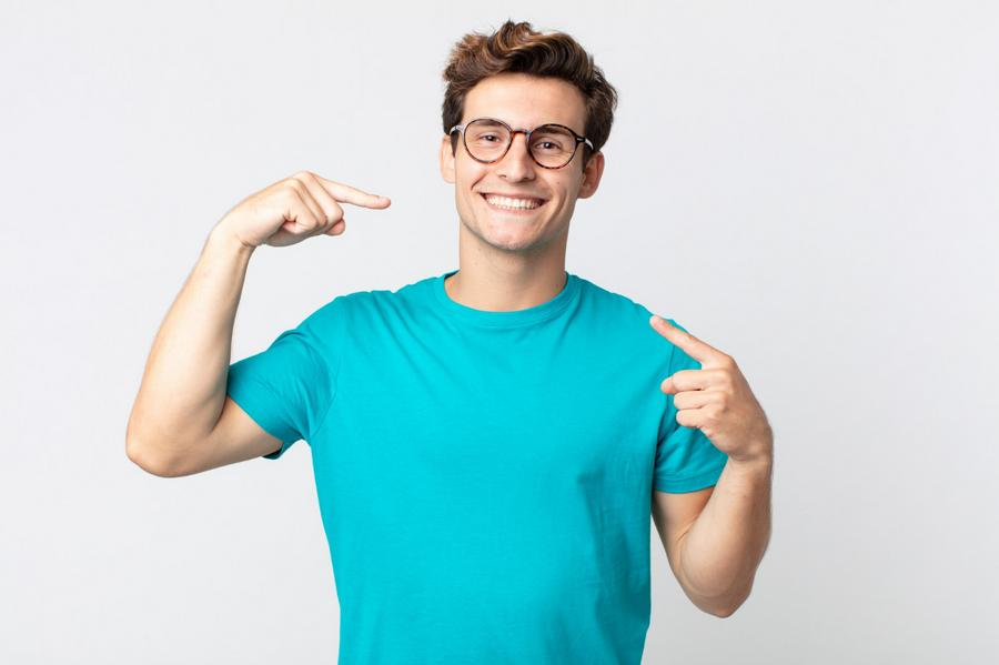 Mężczyzna w okularach w niebieskiej koszulce z pięknym uśmiechem